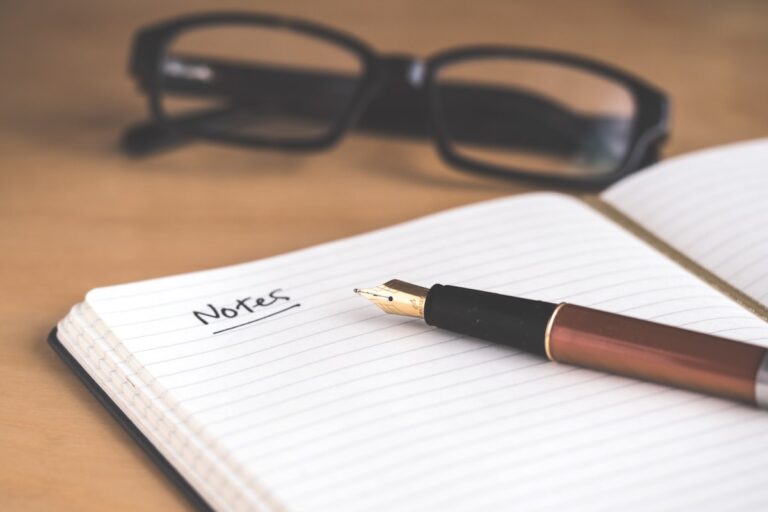 Pessoa praticando escrita reflexiva e journaling em um caderno com xícara de café ao lado