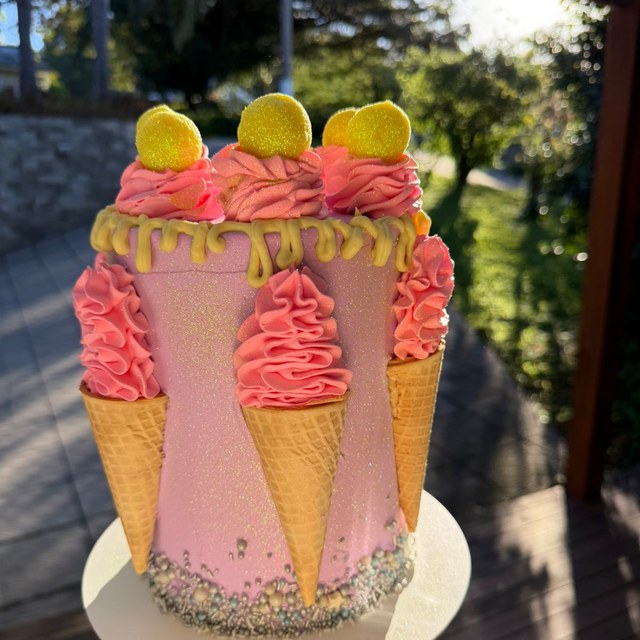 Bolo rosa decorado com cones e chantilly em luz natural