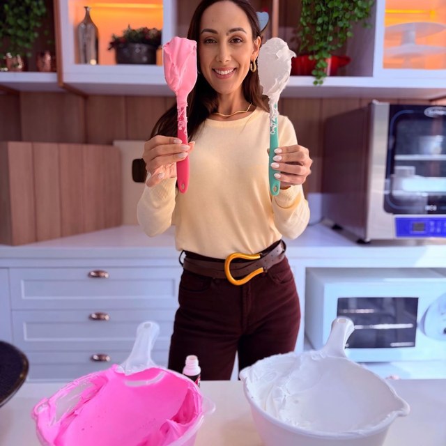 Confeiteira segurando sacos de confeitar em cozinha doméstica